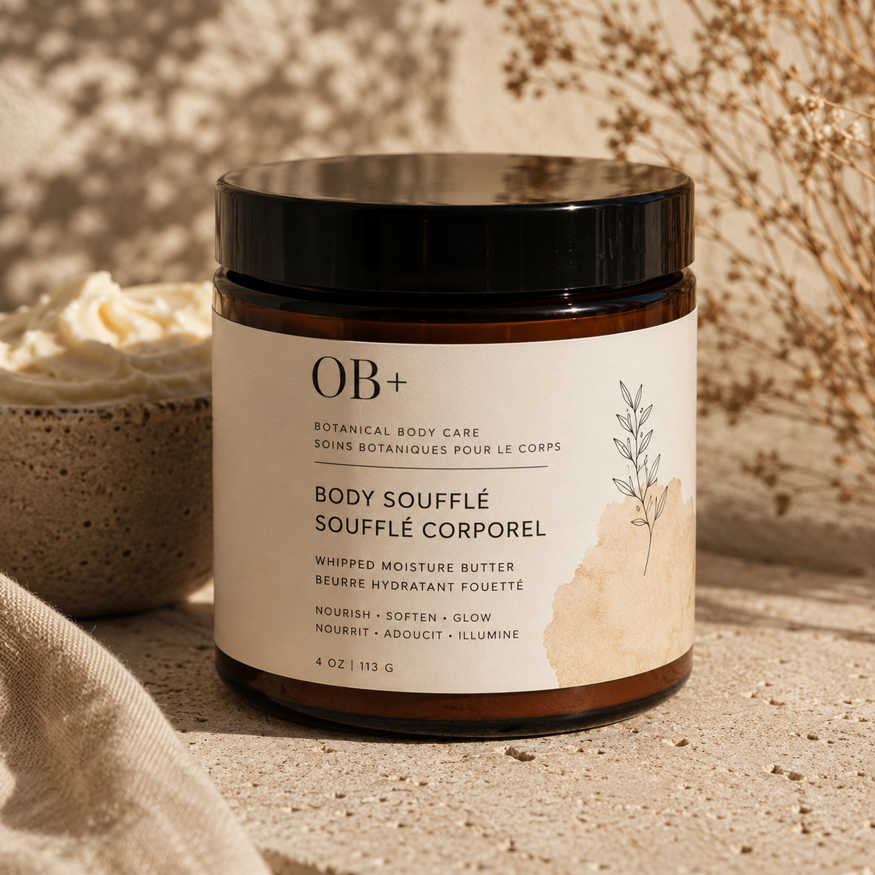 Jar of OB+ Body Souffle on a textured surface with a natural background